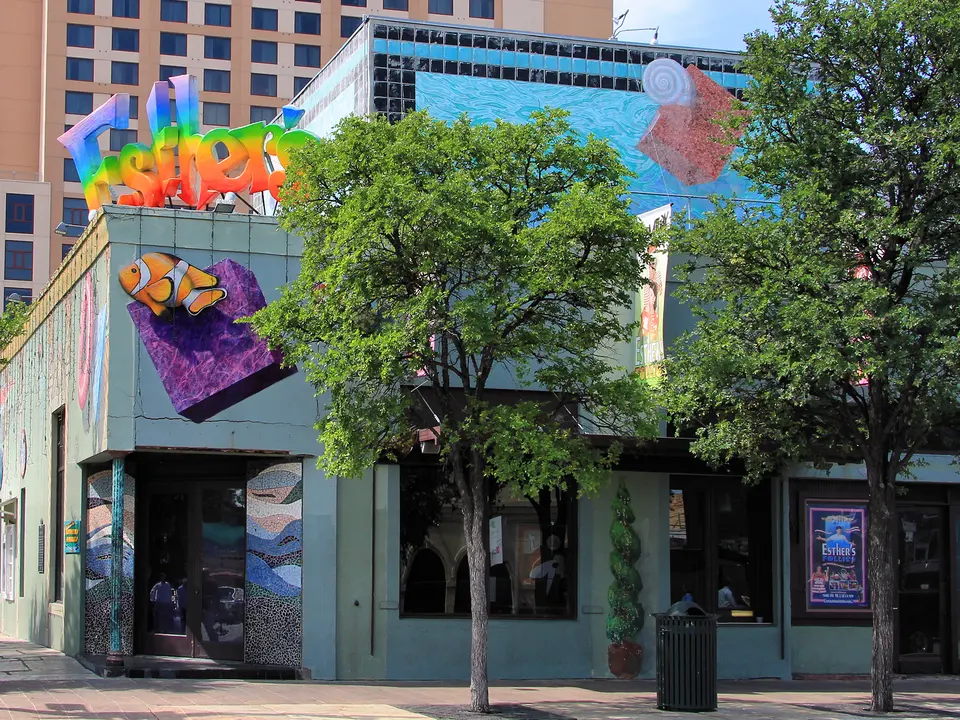 The Esther's Follies theater on Sixth Street in Austin, with a rainbow sign on the roof and a clownfish mural on the wall.
